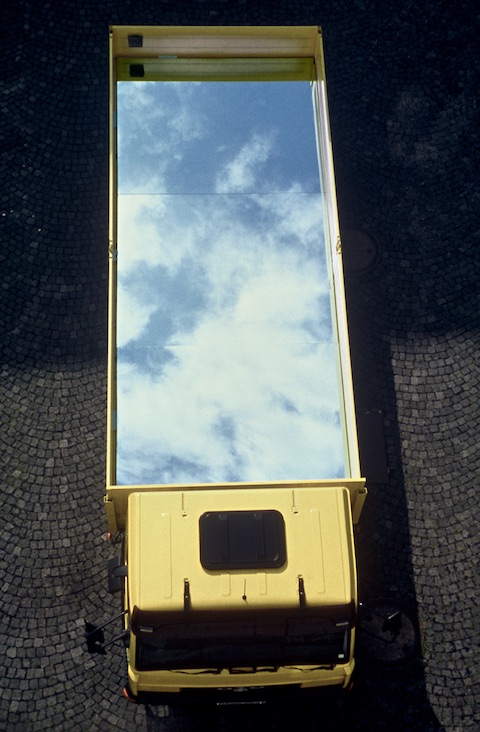 Mirror on van is reflecting the sky when driving. Sky transport.